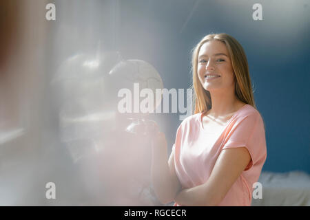 Portrait von lächelnden jungen Frau mit Kugel Stockfoto