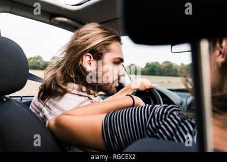 Junge Mann an Frau in einem Auto suchen Stockfoto