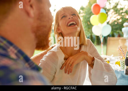 Lachende Frau mit Mann auf einer Gartenparty Stockfoto