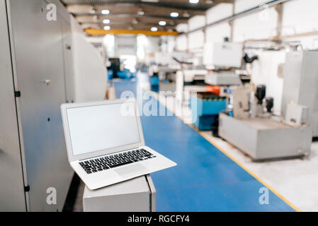 Laptop mit leerer Bildschirm in der Werkhalle Stockfoto