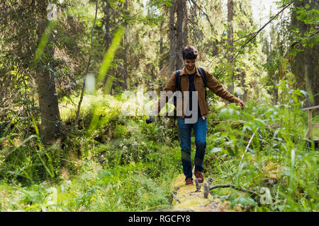 Finnland, Lappland, lächelnde Menschen Balancieren auf in Wald anmelden Stockfoto