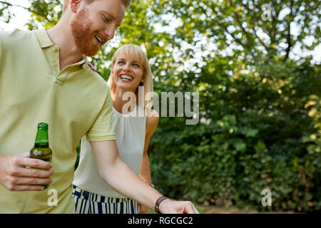 Glückliches junges paar Grillen im Garten Stockfoto