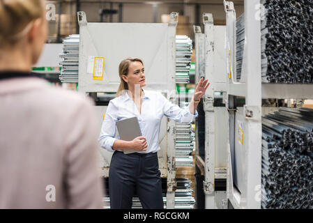 Frau mit Laptop im Hochregallager Stockfoto