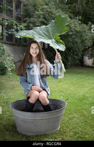 Porträt der lächelnde Mädchen sitzen unter Big im Whirlpool im Garten Stockfoto