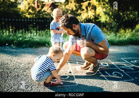 Vater Zeichnung Hopse auf Asphalt Stockfoto