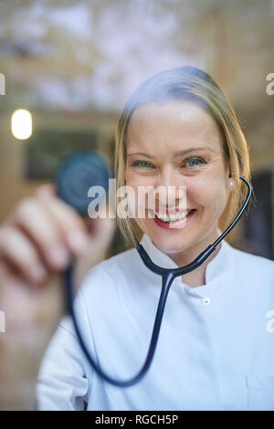 Portrait von lächelnden Frau Doktor holding Stethoskop Stockfoto