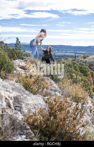 Spanien, Alquezar, junge Frau auf eine Wanderung, eine helfende Hand für einen Freund Stockfoto