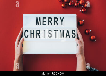 Woman's Hände halten "Frohe Weihnachten!" Zeichen Stockfoto