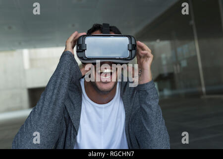 Neugierige junge Mann mit Virtual Reality Brillen Stockfoto