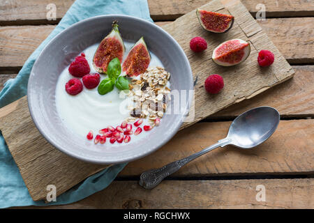 Schüssel Naturjoghurt mit Obst Müsli, Himbeeren, Feigen und Granatäpfel, Saatgut Stockfoto