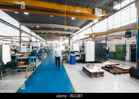 Geschäftsmann zu Fuß durch Factory workshop Stockfoto