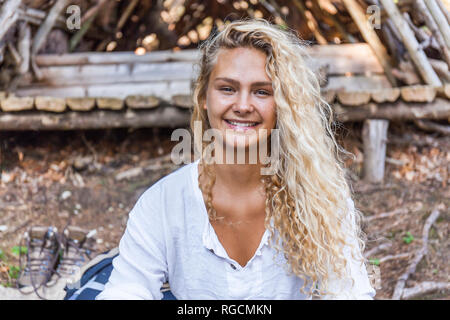 Portrait von lächelnden jungen Frau an der hölzernen Unterstand Stockfoto