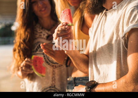 In der Nähe von Freunden essen Wassermelone im Freien Stockfoto