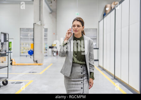 Geschäftsfrau wandern in der Werkstatt, am Telefon zu sprechen Stockfoto