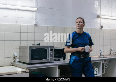 Junge Frau, die in High-Tech-Unternehmen, Pause machen, Kaffee trinken Stockfoto