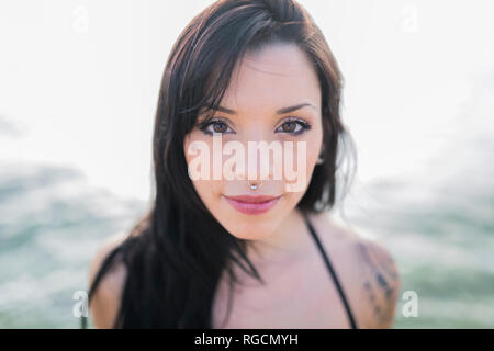 Portrait von lächelnden jungen Frau mit nasenpiercing am Meer Stockfoto