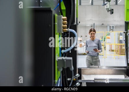 In High-Tech-Unternehmen, das Maschinen zur Herstellung von Geschäftsfrau, mit digitalen Tablet Stockfoto