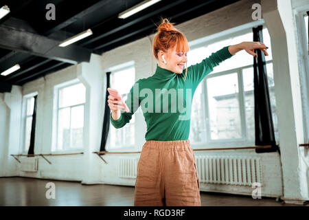 Rothaarige professionelle Yogalehrer in einer grünen Rollkragen positiv lächelnd Stockfoto