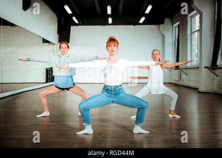 Schlanke schöne Ballett Lehrer tun Hausbesetzung mit zwei jungen Studenten Stockfoto