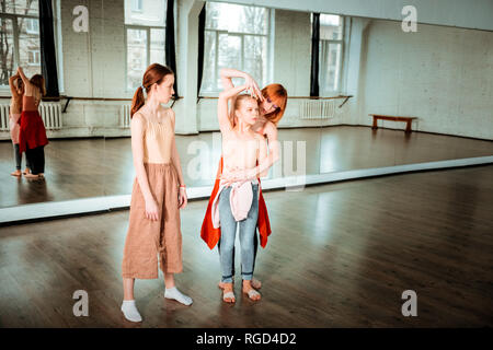 Rothaarige schlanke Tanzlehrer Übersicht arm Position zu ihr Student Stockfoto