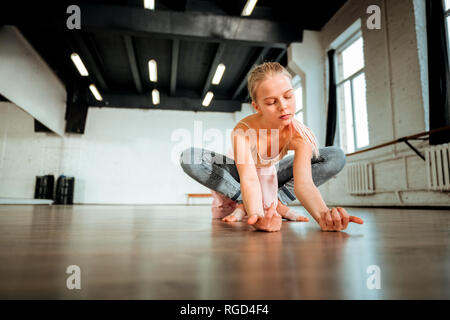 Schöne blonde Teenager von Generation z Sitzen im Lotussitz Stockfoto