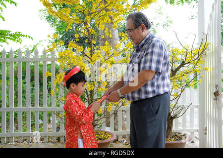 Großvater und Enkel glücklich Geld am ersten Tag der vietnamesischen Neujahrsfest Tet Stockfoto