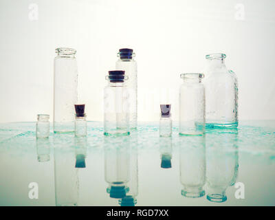 Wenige transparente Flaschen, Wasser spritzt. Leere Glasflaschen Stockfoto