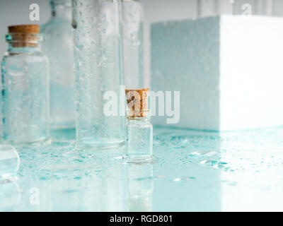 Wenige transparente Flaschen, Wasser spritzt. Leere Glasflaschen Stockfoto
