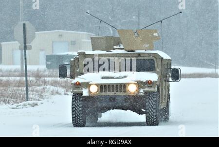 Soldaten am Fort McCoy für Training betreiben einen gepanzerten Humvee auf 23.01.2019, In der Schnee auf der cantonment Bereich am Fort McCoy, Wis der High Mobility Multipurpose Radfahrzeug (Hmmwv oder Humvee) ist eine Familie von Licht, Allradantrieb, militärische Lkws und Nutzfahrzeuge von AM General produziert. Es hat sich weitgehend die Rollen bereits erfolgt durch den ursprünglichen Jeep verdrängt, und andere wie der M151 Jeep, der M 561 Gama Goat und andere leichte Nutzfahrzeuge. Vor allem durch die Vereinigten Staaten militärisch genutzt, sondern auch von zahlreichen anderen Ländern und Organisationen verwendet und sogar in zivilen Anpassungen. Stockfoto