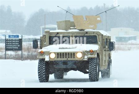 Soldaten am Fort McCoy für Training betreiben einen gepanzerten Humvee auf 23.01.2019, In der Schnee auf der cantonment Bereich am Fort McCoy, Wis der High Mobility Multipurpose Radfahrzeug (Hmmwv oder Humvee) ist eine Familie von Licht, Allradantrieb, militärische Lkws und Nutzfahrzeuge von AM General produziert. Es hat sich weitgehend die Rollen bereits erfolgt durch den ursprünglichen Jeep verdrängt, und andere wie der M151 Jeep, der M 561 Gama Goat und andere leichte Nutzfahrzeuge. Vor allem durch die Vereinigten Staaten militärisch genutzt, sondern auch von zahlreichen anderen Ländern und Organisationen verwendet und sogar in zivilen Anpassungen. Stockfoto