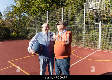 Zwei fit Senioren Spaß auf ein Basketball Feld Stockfoto