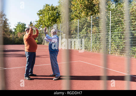 Zwei fit Senioren hohe FIVING auf ein Basketball Feld Stockfoto