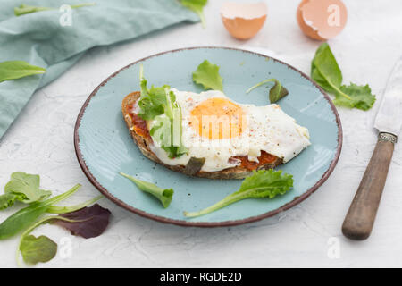 Spiegelei auf Scheibe Graubrot, beschichtet mit paprikacreme auf Platte Stockfoto