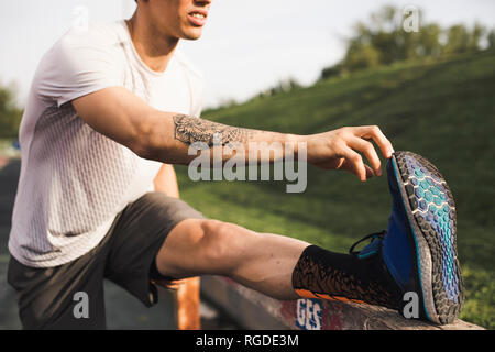 Männliche Athlet, Warm-up Übungen auf einer Laufstrecke Stockfoto