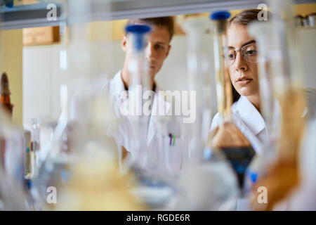 Junger Mann und Frau zusammen, die im Labor arbeiten Stockfoto