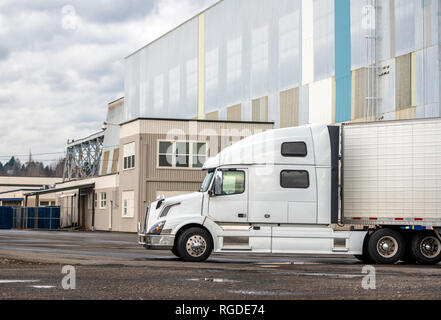 Weiß Big Rig Long Haul Semi Truck mit hoher Kabine und reefer Auflieger auf Parkplatz Warten auf Laden und die Möglichkeit der Fortführung der zu Stockfoto