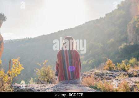 Spanien, Alquezar, Rückansicht der jungen Frau auf eine Wanderung auf einem Stein saß Stockfoto