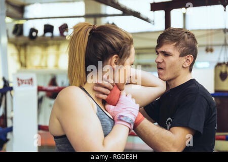 Weibliche Martial Artist Sparring mit Trainer Stockfoto