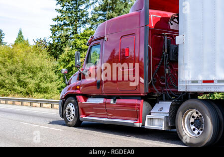 Big Rig hell rot Classic American Idol moderne Sattelschlepper Lkw mit hoher Kabine für die Fernbeförderung routs Transport Auflieger fahren auf der geraden Autobahn Stockfoto