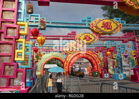 Eine Mutter und eine Tochter, die das chinesische Neujahr Dekorationen (Jahr des Schweins) an der Esplanade, Marina Bay, Singapore Stockfoto