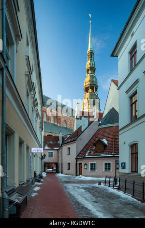 Winter am Abend in der Altstadt von Riga, Lettland. St Peter's Church Tower in der Ferne. Stockfoto