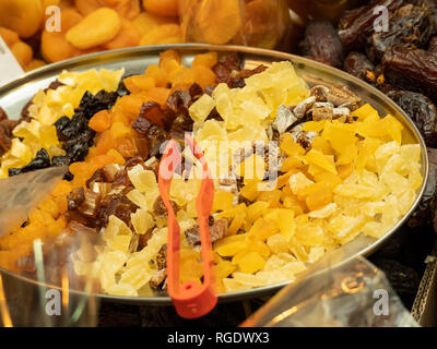 Kandierte Früchte getrocknet mit Zangen auf einer Platte auf einem Markt in South London, UK. Stockfoto