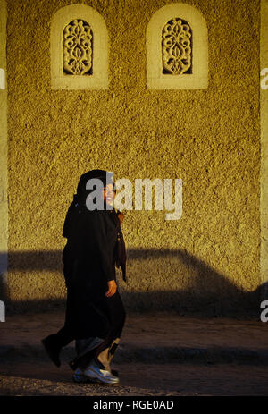 BORDJ EL HAOUAS, ALGERIEN - Januar 16, 2002: Unbekannte muslimische Frauen Spaziergang im Licht des Sonnenuntergangs Stockfoto