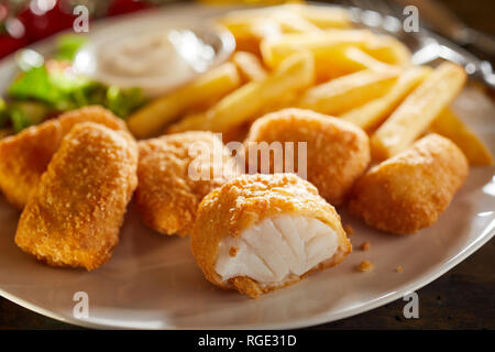 Leckere Meeresfrüchte Vorspeise der Fried kibbeling, einem niederländischen Rezept des mundgerechte Portionen von Kabeljau paniert mit Pommes Frites und Salat serviert. Stockfoto