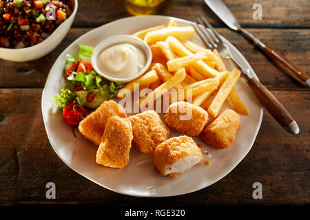 Platte von knusprigem Golden kibbeling, oder Beißen große Stücke von Panierte frittierte Kabeljau, mit Pommes, Salat und eine Mayonnaise dip auf einem urigen Stockfoto