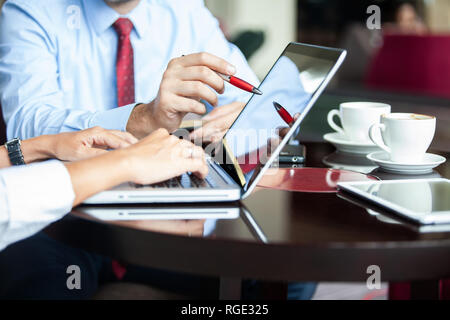 Zwei Kollegen diskutieren Daten mit neuen modernen Computer Laptop auf dem Schreibtisch Tisch. Close up Business Team Analyse und Strategie Konzept. Stockfoto