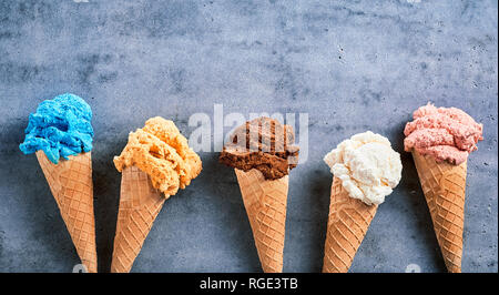 Sortierte Spezialität Eissorten in Zucker Kegel in Banner Format angeordnet, wie eine Grenze mit Kopie Speicherplatz auf strukturierte Schiefer mit Platz kopieren Stockfoto