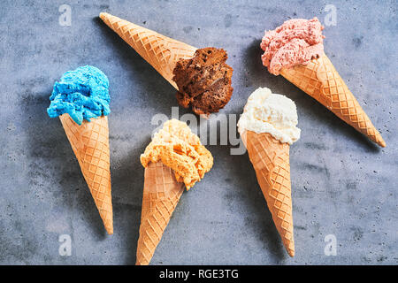 Fünf verschiedene Geschmacksrichtungen der Gourmet Sommer Eis Zucker Kegel auf grauem Schiefer Hintergrund verstreut Stockfoto
