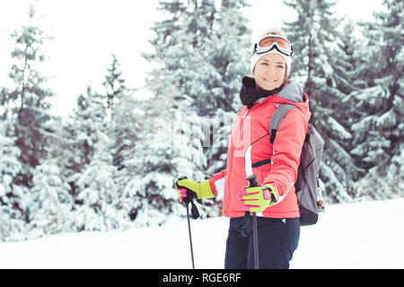 Glückliche junge Frau, die Skifahrer im Winter in den Bergen genießen. Stockfoto