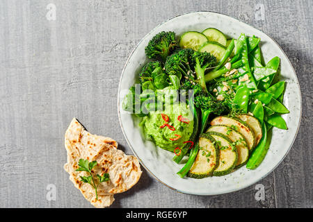 Buddha Schüssel voller grünes Gemüse mit Avocado dip und Naan Brot Stockfoto